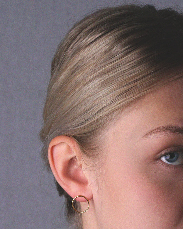 Modell kannab kuld vermeil keskmise rõnga suurusega kõrvarõngaid - šikk meeleolu garanteeritud.