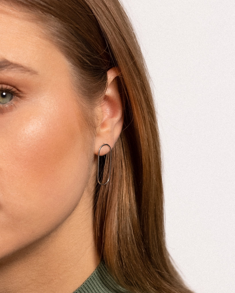 Modell kannab ovaalseid hõbe kõrvarõngad.