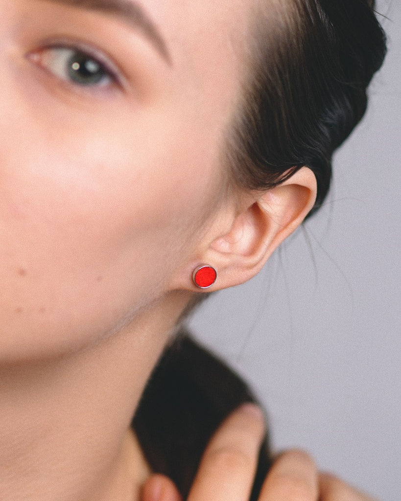 Model wearing Cosmic earrings - Handcrafted birch wood and sterling silver studs with a  distant red birch wood interior, plated with platinum.