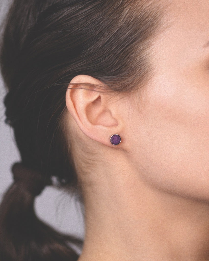 Model wearing Cosmic earrings - Handcrafted birch wood and sterling silver studs with a  orion purple birch wood interior, plated with platinum.