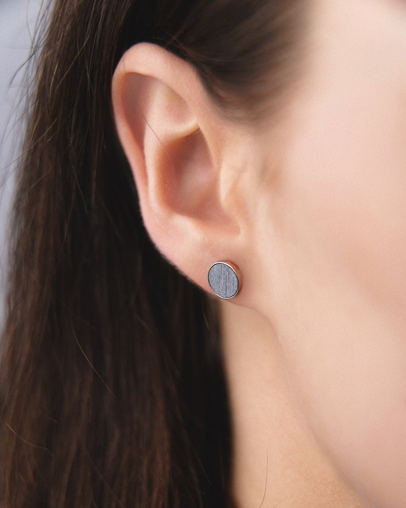 Model wearing Cosmic earrings - Handcrafted birch wood and sterling silver studs with a  luna grey birch wood interior, plated with platinum.