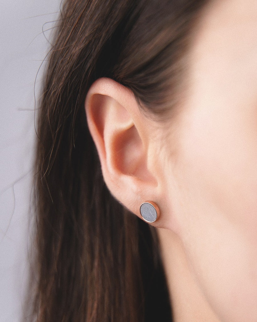 Model wearing Cosmic earrings - Handcrafted birch wood and sterling silver studs with a  luna grey birch wood interior, plated with 18k rose gold.