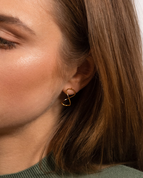 Modell kannab Curl Infinity Kõrvarõngaid, 24k kullatud hõbe.