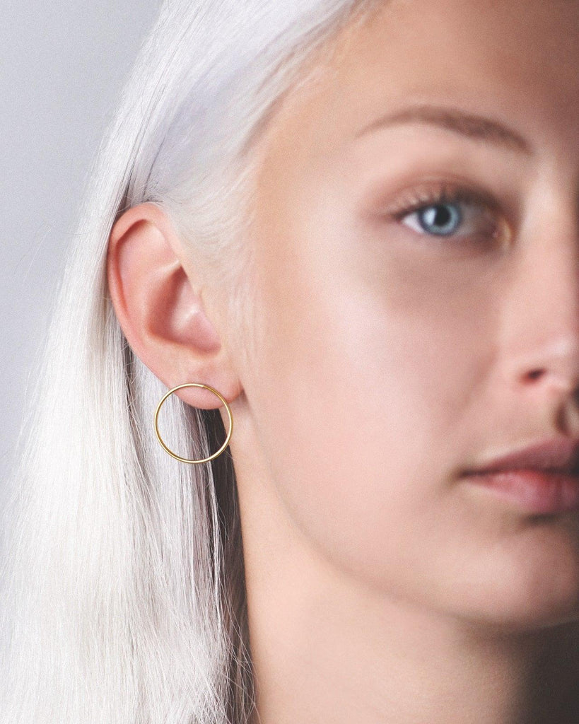 Model showcasing the stunning gold vermeil large hoop earring studs for a fashionable and chic appearance.