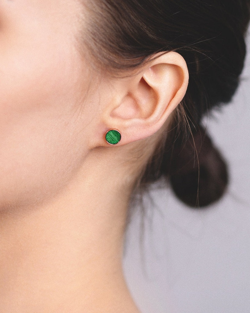 Model wearing Cosmic earrings - Handcrafted birch wood and sterling silver studs with a  aurora green birch wood interior, plated with 18k rose gold.
