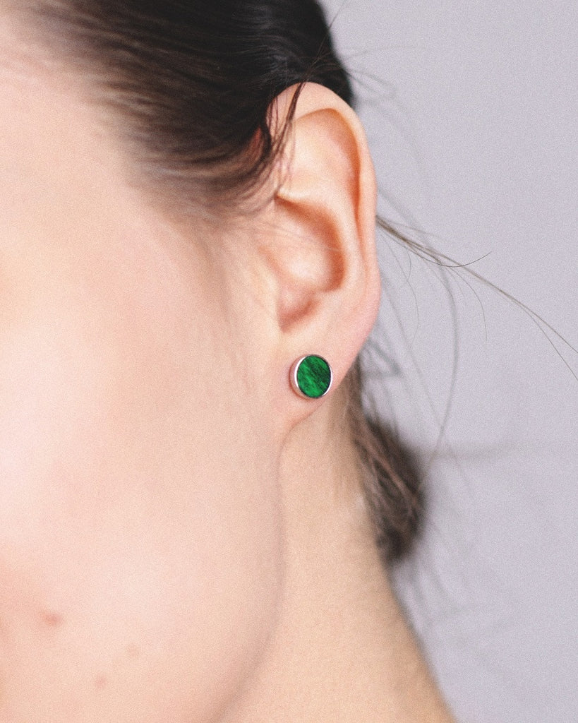 Model wearing Cosmic earrings - Handcrafted birch wood and sterling silver studs with a  aurora green birch wood interior, plated with platinum.